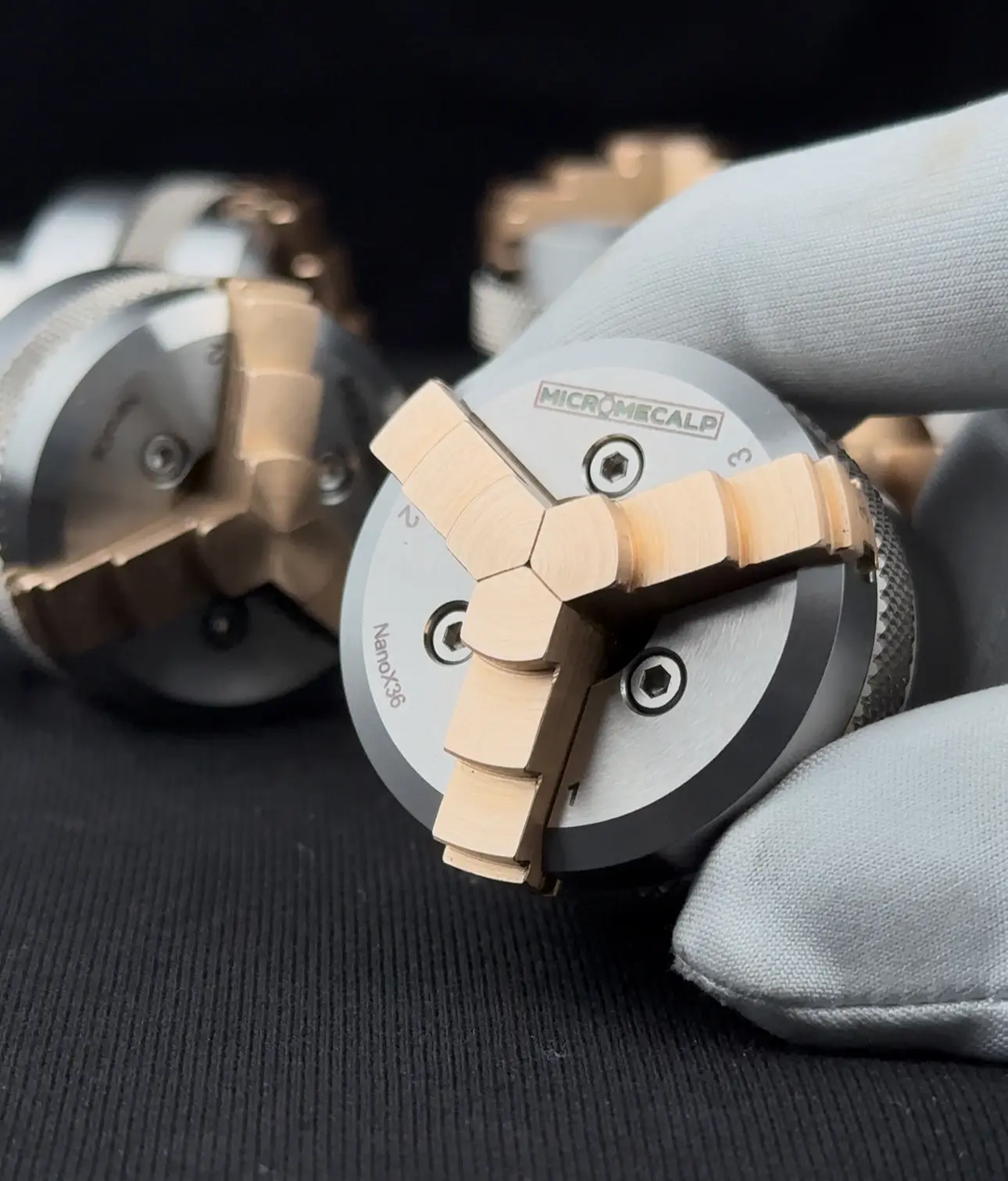 Nano X36 three-jaw chuck with rectified brass jaws holding a watch case